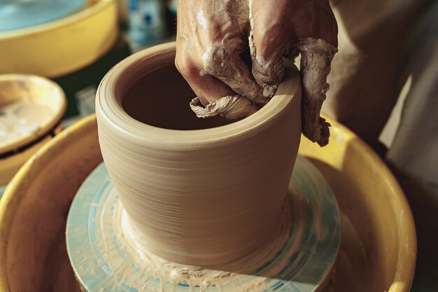 Création d'un pot ou d'un vase en gros plan d'argile blanche. Maître crock.
