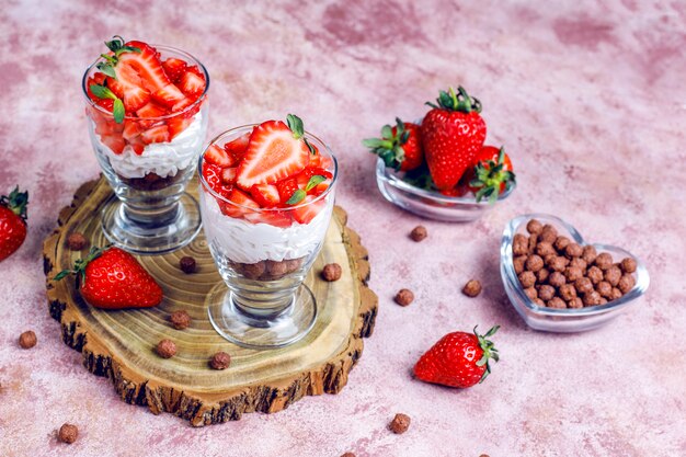 Crème fouettée et bagatelle aux fraises avec du miel et des céréales.