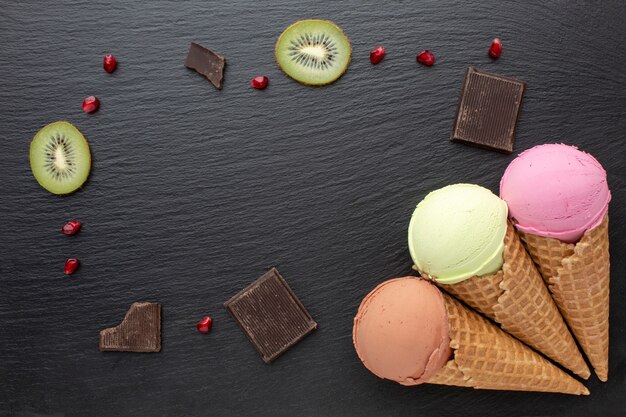 Crème glacée sur cônes avec chocolat et kiwi sur table