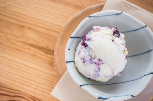 la crème glacée à la fraise dans un bol sur la table en bois.