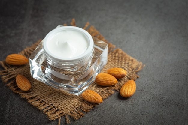 Crème hydratante pour le corps aux amandes sur fond sombre