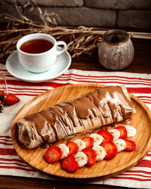 Crêpe aux fruits fraise banane chocolat thé vue latérale