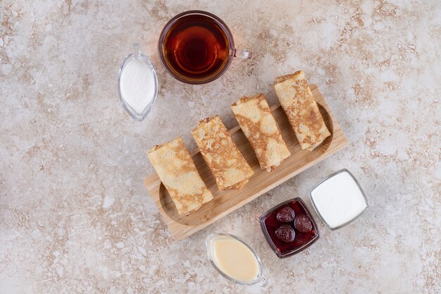 Crêpes maison sucrées avec une tasse de thé chaud