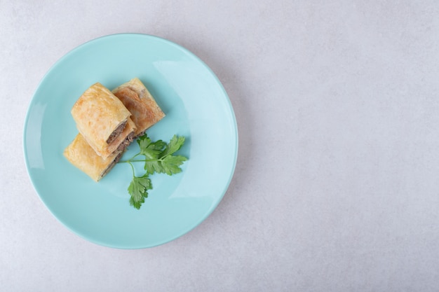 Crêpes tranchées avec de la viande sur plaque, sur le marbre.