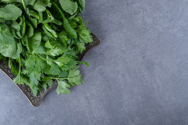 Cresson frais sur un plateau, sur la surface en marbre.