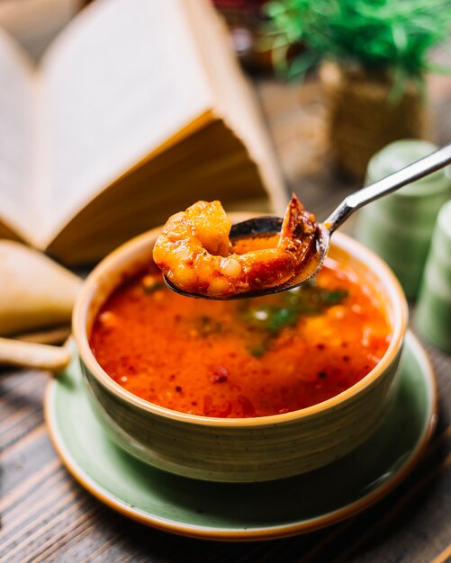 Crevettes à la cuillère soupe de fruits de mer crevettes pain tomate vue latérale