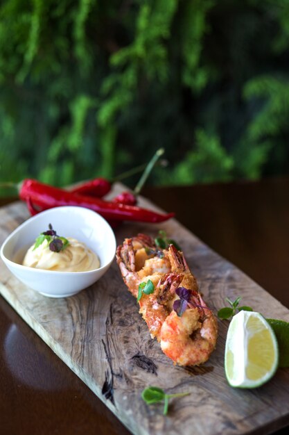 Crevettes frites servies avec mayonnaise, piment et citron