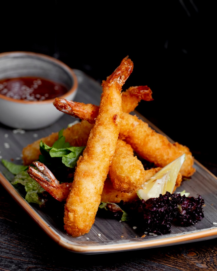 Photo gratuit crevettes frites servies avec tranches de citron laitue et sauce