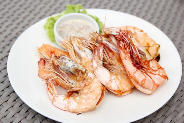Crevettes grillé avec sauce de fruits de mer sur assiette blanche