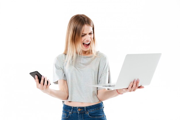 Cri de femme en colère avec smartphone et ordinateur portable