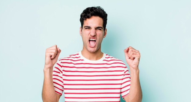 crier agressivement avec une expression de colère ou avec les poings serrés pour célébrer le succès