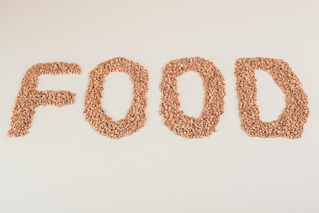 Écriture alimentaire sur un béton avec des haricots bruns.