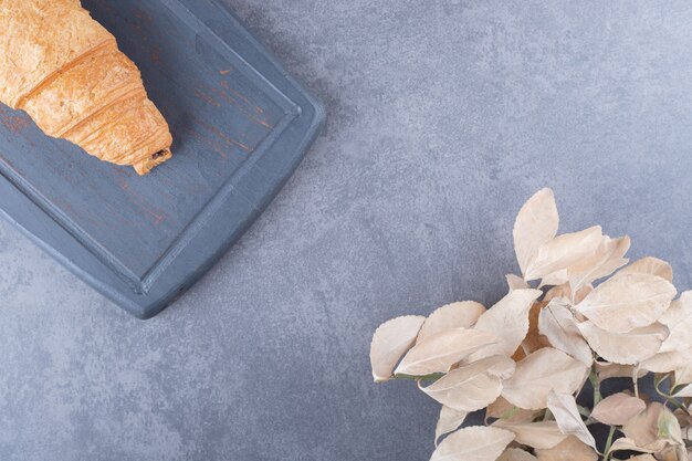 Croissant délicieux fraîchement sorti du four sur planche de bois. fermer.