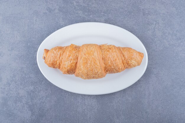 Croissant Français Fraîchement Sorti Du Four Sur Plaque Blanche Sur Fond Gris.