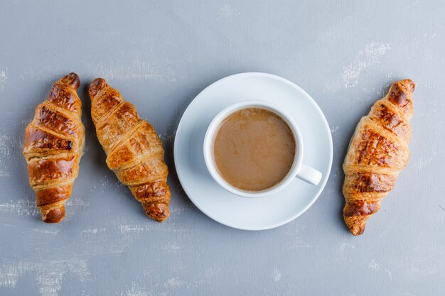 Croissant avec tasse de café, pose à plat.