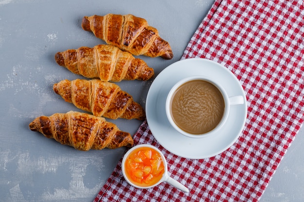 Photo gratuite croissants au café, sauce à plat sur du plâtre et un chiffon de pique-nique