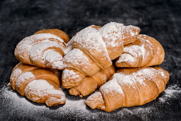 croissants au sucre en poudre sur table grise.