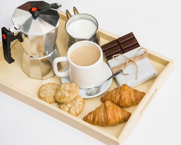 Croissants, biscuits, chocolat, thé et lait sur plateau