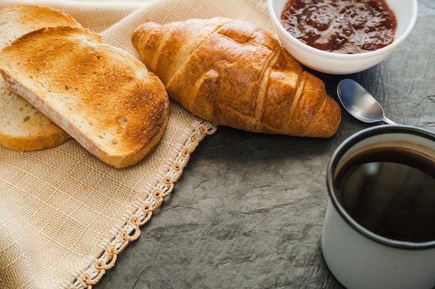 Croissants avec de la confiture et du café