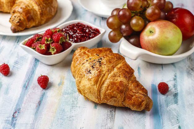 Croissants fraîchement sortis du four avec confiture de framboises et framboises.