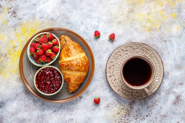 Croissants frais avec confiture de framboises et framboises.