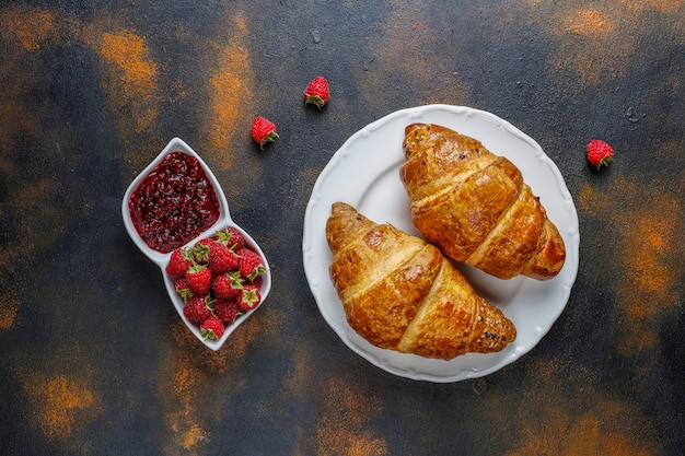 Photo gratuite croissants frais avec confiture de framboises et framboises.