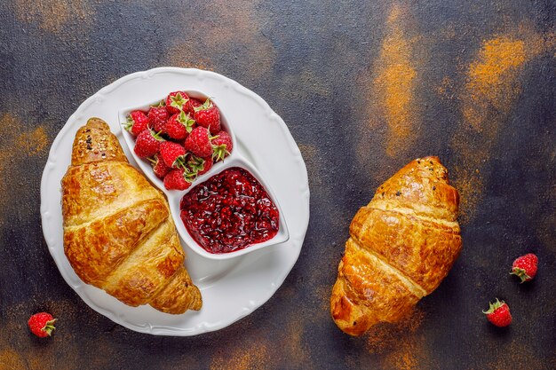 Croissants frais avec confiture de framboises et framboises.