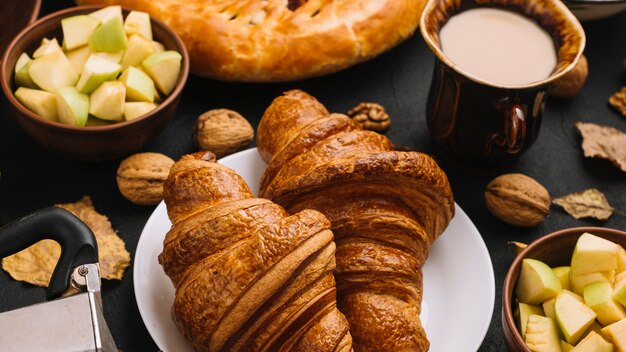 Croissants près des pommes et du lait