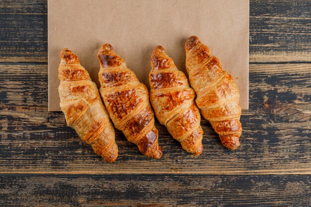 Photo gratuite croissants sur sac en bois et papier. pose à plat.