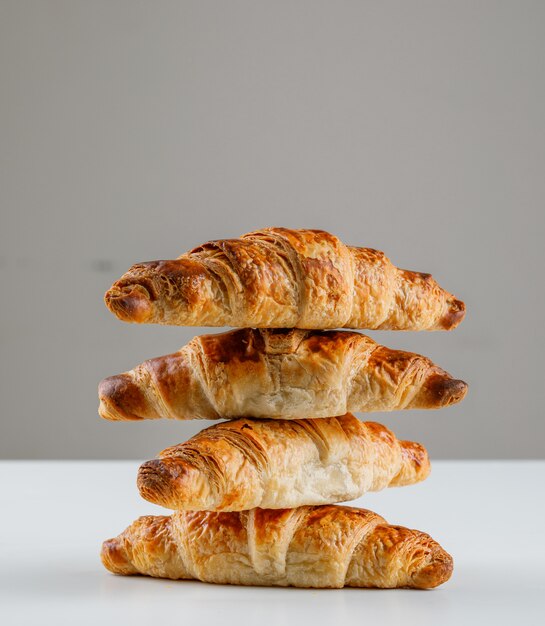 Croissants sur table blanche et grise. vue de côté.