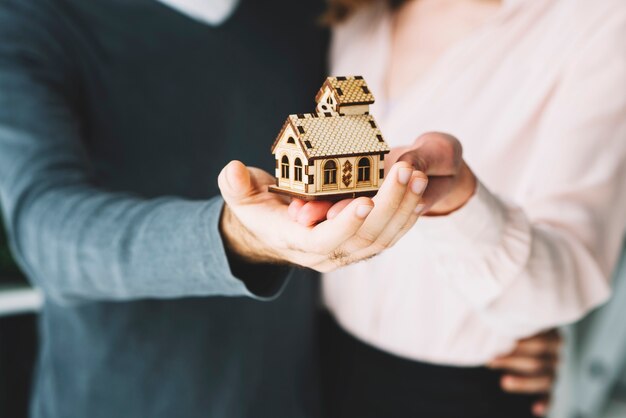 Crop couple tenant la maison de jouet