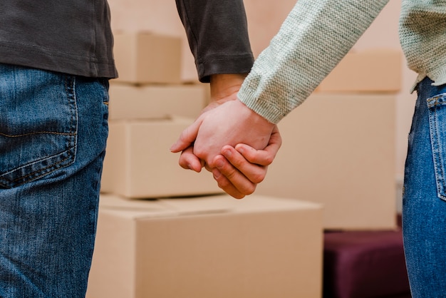 Crop couple tenant par la main près de boîtes en carton