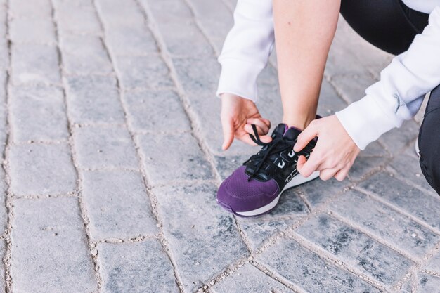 Crop femme attachant des lacets sur des baskets