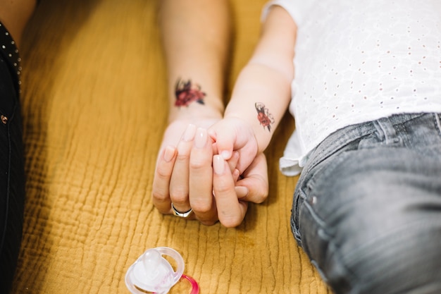 Crop femme et bébé tenant par la main