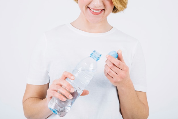 Crop femme avec une bouteille ouverte sur blanc