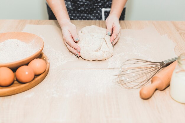 Crop femme faisant de la pâte à pain