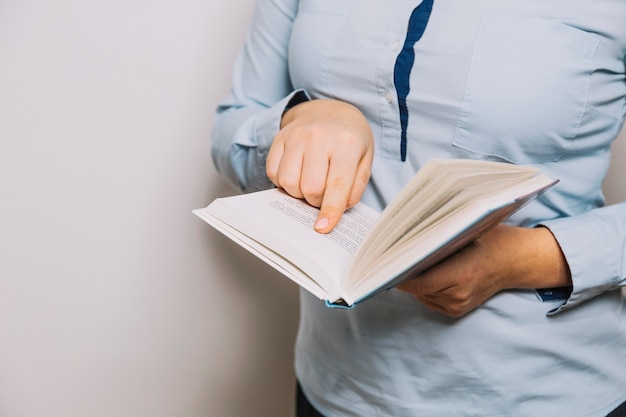 Crop femme pointant sur la page du livre