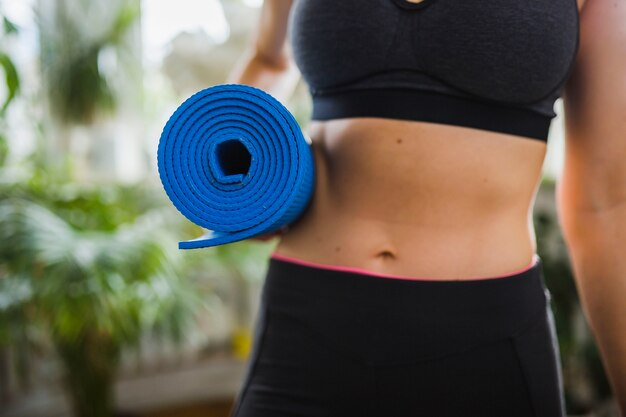 Crop femme portant des tapis de yoga