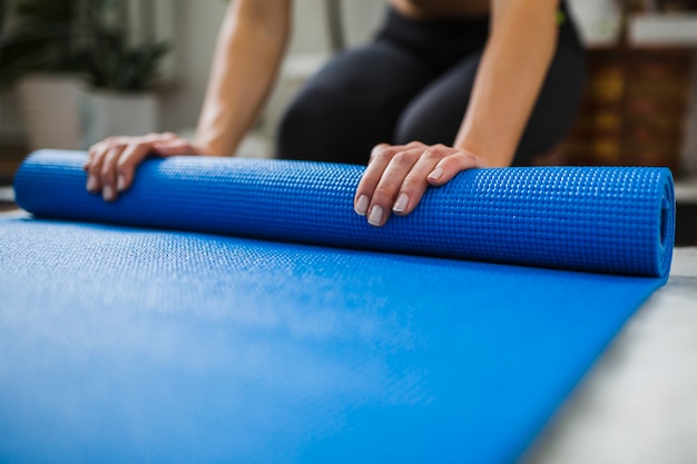 Crop femme roulant sur le tapis d&#39;étirement