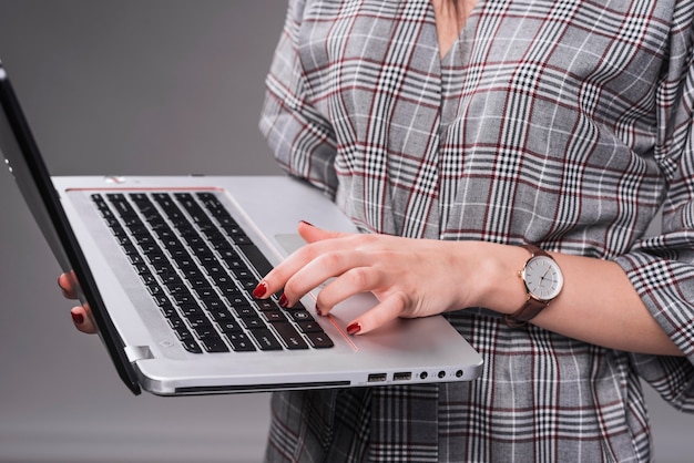 Crop femme utilisant un ordinateur portable