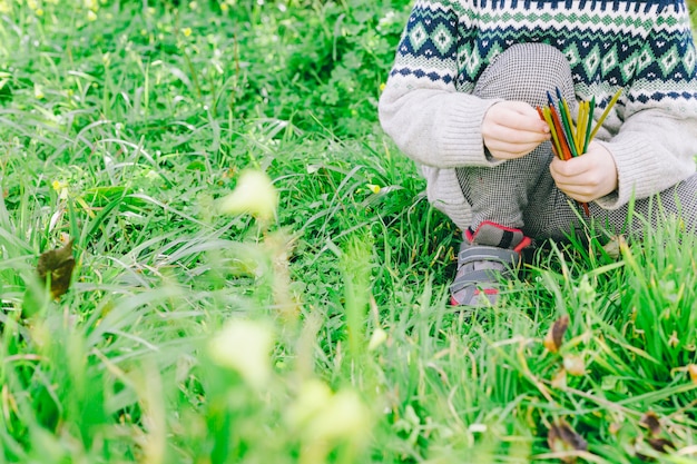 Crop girl assise sur l&#39;herbe du jardin