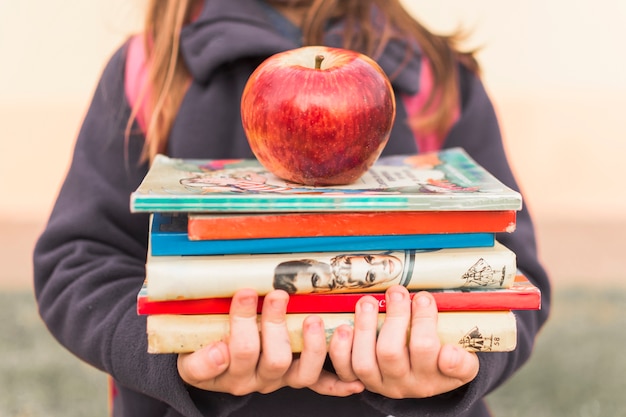 Photo gratuite crop girl avec des livres et des pommes