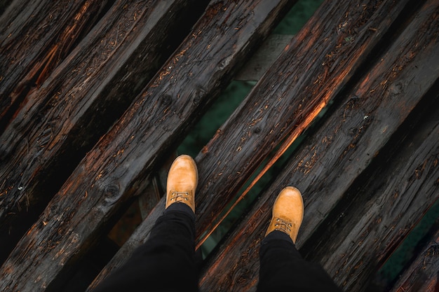 Photo gratuite crop jambes sur le pont en bois