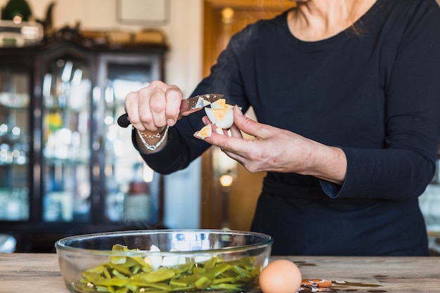 Crop mains d&#39;une femme âgée cuisine plat délicieux dans la cuisine