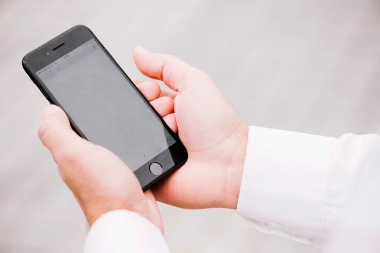 Photo gratuit crop mains tenant un smartphone noir