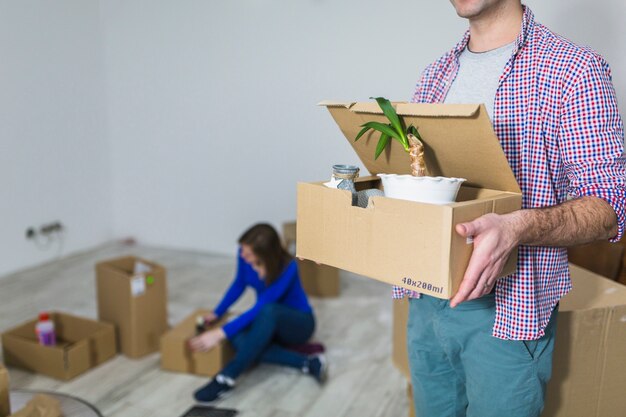 Crop man transportant la boîte avec plante