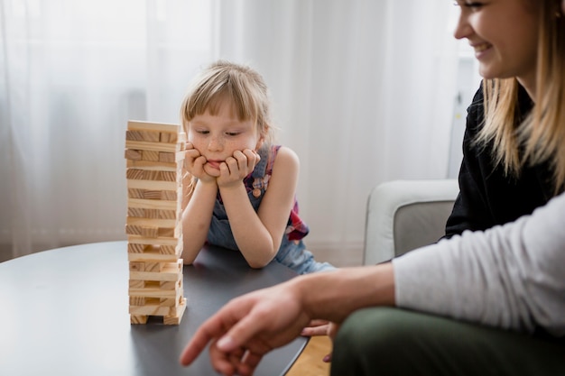 Crop parents jouant jenga avec sa fille