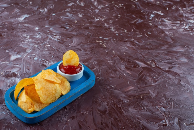 Croustilles Au Ketchup Dans Une Assiette En Bois , Sur La Table En Marbre.