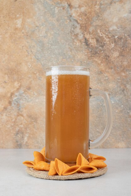 Croustilles croustillantes avec de la bière froide sur une surface en marbre