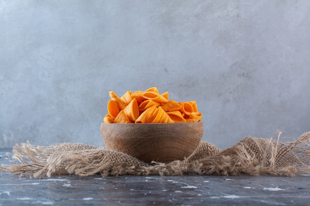 Croustilles de pommes de terre épicées dans un bol sur la texture, sur la surface en marbre